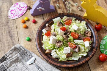 Holiday food, easter salad. Salad with chinese cabbage, feta, cherry tomatoes and canned tuna and vinegar dressing on a festive table. Copy space.