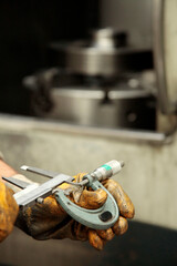 Metal measuring instruments in worker's hand. Vernier caliper measurement, Micrometer .