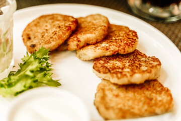 Potato pancakes or draniki or latkes on a plate in a restaurant. Traditional potato dish and food in Eastern Europe and Israel