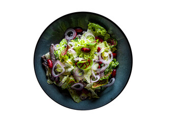 Mediterranean red beans salad with mix of lettuce leaves and onion in black plate isolated on white background