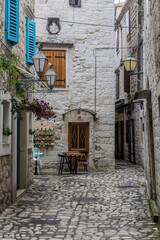 Fototapeta na wymiar TROGIR, CROATIA - MAY 27, 2019: Narrow alley in the old town of Trogir, Croatia
