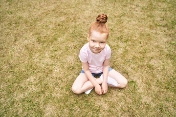 Pretty face. Red hair. Cute school child doing yoga exercise. Active vacation. Small people in lotus pose. Online video call. Happy children concept. Lifestyle action. Sport lesson