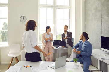 Group of young people having a discussion during a meeting in a modern company office. Team of...