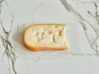 Cheddar cheese in package, natural lifestyle, dairy products, marble background.