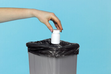 throw a jar of pills in the trash can, a jar of drugs in hand in front of the trash can