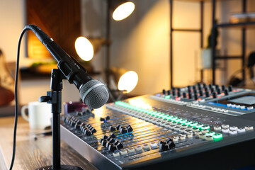 Microphone and professional mixing console on table in radio studio