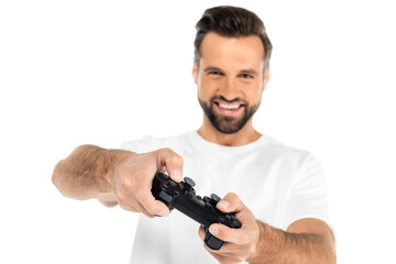 KYIV, UKRAINE - DECEMBER 5, 2021: blurred man smiling while gaming with joystick isolated on white.