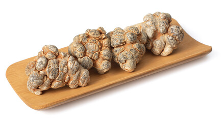 Dried herb, notoginseng roots in the wooden plate, isolated on white background