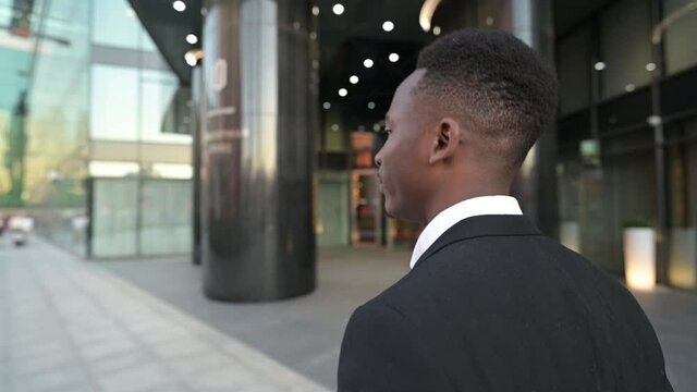 Young black man walking in the business center. slowmotion