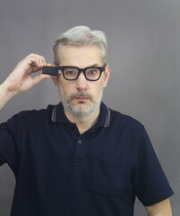 Obraz premium Middle age men connected microchip device to his head. Upload information, technology and extra memory concept.