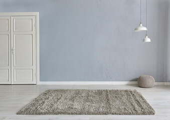 Grey stone wall background with white wooden door, lamp carpet and home style, poster decoration...