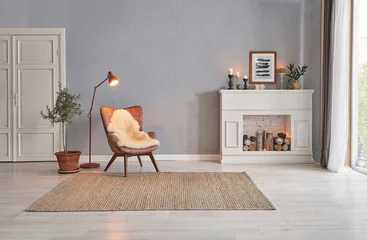 Foto op Plexiglas Modern room concept interior style, chair fireplace frame wicker carpet decoration, grey stone wall background. © UnitedPhotoStudio