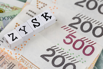 The wording "Zysk" translated as "Profit" plus many Polish banknotes. Photo taken under artificial, soft light