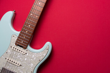 Electric guitar on red table background, close up