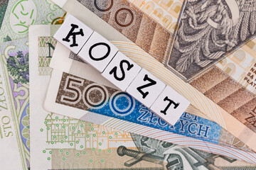 The wording "Koszt" translated as "Cost" and many Polish banknotes. New taxation rules in Poland. Photo taken under artificial, soft light