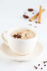 Fotobehang Masala tea with milk, ginger root and spices in a mug on a table. © 7707601