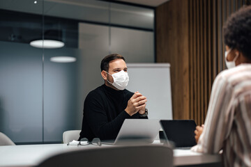Serious caucasian man wearing a mask, fixing the problem in the company.