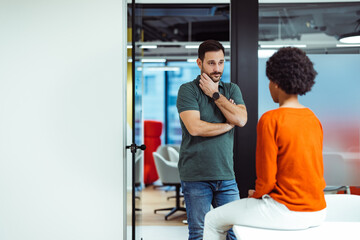 Pensive caucasian man, standing thoughtfully in the company hall, with his colleague.