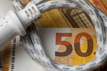 Electric cable with socket on the background of 50 Euro bill. Rise of electricity price in Europe....
