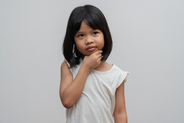 Portrait of Asian child 5 year old and to collect hair and Place her hands on her chin and make thinking pose on isolated white background, She is Happiness, radiance in youth, Education Concept