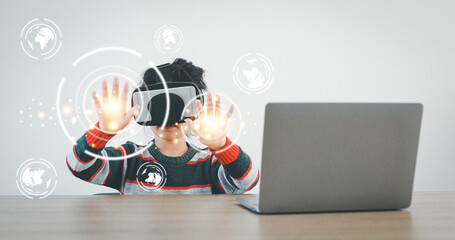 The little girl wearing VR sitting at desk in the home glasses virtual Global Internet connection metaverse. Future kids in white clothing wearing VR headsets for a game. concept advanced technology.