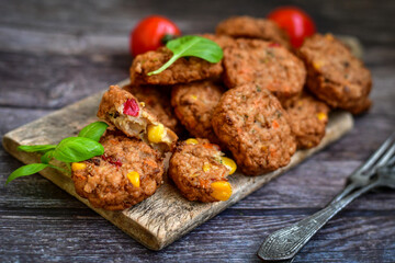 Home made baked chicken and vegetables  meatballs with fresh parsley and organic bio cherry tomatoes on black background