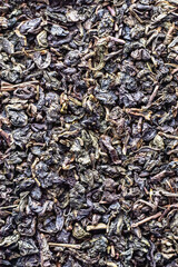 Dried green tea leaves texture, top view