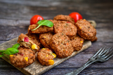 Home made baked chicken and vegetables  meatballs with fresh parsley and organic bio cherry tomatoes on black background