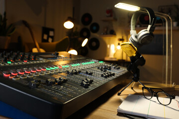 Microphone and professional mixing console on table in radio studio