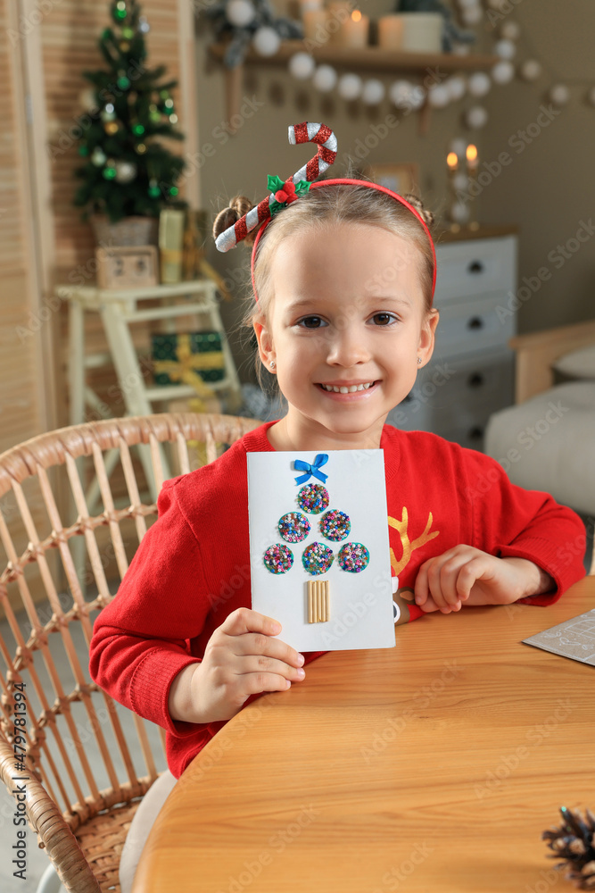 Poster cute little child with beautiful christmas greeting card at home