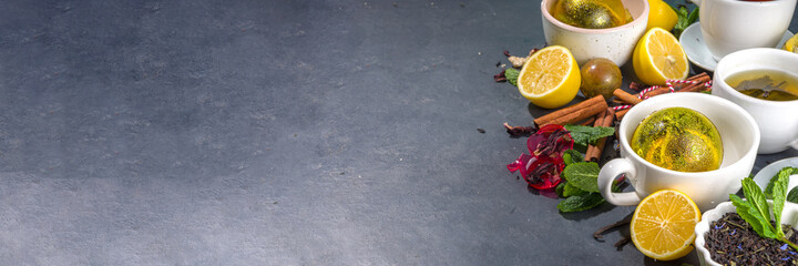 Various tea ball bombs. Assortment of different tea balls with dried tea, cups, lemon and mint, top view copy space. Trendy modern tea variety