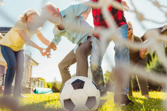 Senior People Playing Football In The Backyard