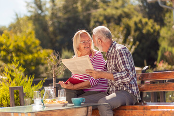 Senior couple reading in the backyard