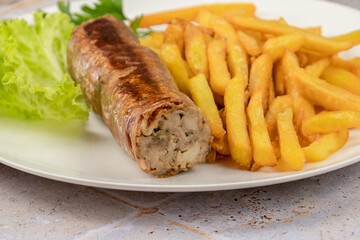 grilled andouillette with french fries and salad leaves
