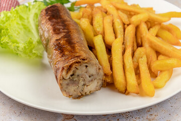 grilled andouillette with french fries and salad leaves
