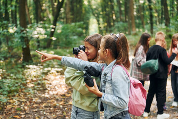 Fototapeta premium Looking for a path. Kids in green forest at summer daytime together