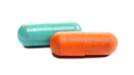 Orange and green pills macro, medicine isolated on white  