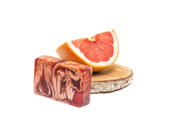 Grapefruit slices and a bar of red natural soap on a white background. Isolated. Natural cosmetics concept