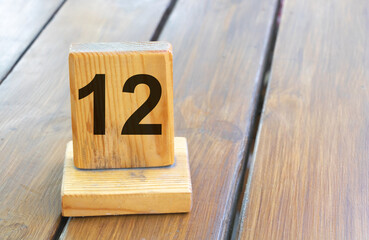 Wooden priority number 12 on a plank tab