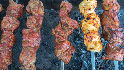 Tasty food roasting on skewers. Delicious bbq kebab grilling on open grill. Outdoor kitchen. Food festival in city.