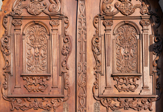Detail of wood carving on historic church door with renaissance mascarons, Jesuit church in Bratislava