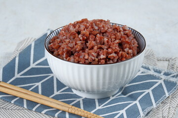 Fototapeta na wymiar cooked red rice in white bowl on white background 