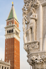 Fototapeta na wymiar Statue of Eve with apple on corner of Doge's Palace in Venice with St Mark's Campanile in background
