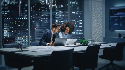 Businesspeople in Modern Office: Business Meeting of Two Managers. Accountant and Operations Director Talk, Discuss, Brainstorm Corporate Strategy, Implementing Budget and Financial Plans. Night.