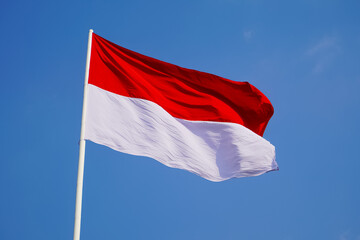 Fototapeta na wymiar The single large red and white Indonesian flag flutters in the strong wind ahead of the 77th Independence Day of the Republic of Indonesia. 
