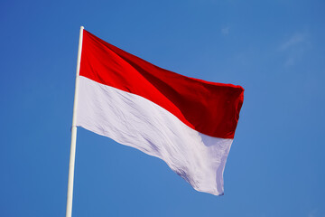 Naklejka na ściany i meble The single large red and white Indonesian flag flutters in the strong wind ahead of the 77th Independence Day of the Republic of Indonesia.