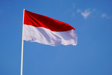 The single large red and white Indonesian flag flutters in the strong wind ahead of the 77th Independence Day of the Republic of Indonesia.