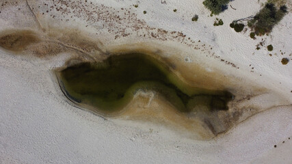 Aerial top view of small shallow lake among white sand on Dzharylhach island. Ukraine
