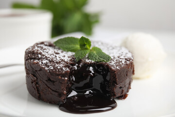 Delicious fresh fondant with hot chocolate, mint and ice cream served on plate, closeup