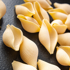 raw pasta Conchiglioni seashells mold form ingredient healthy meal food snack on the table copy space food background